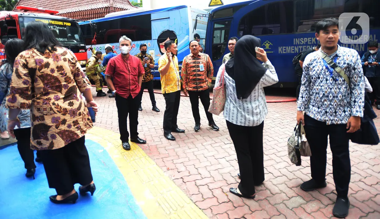 Pegawai berhamburan di luar Gedung Kemenkumham saat terjadi kebakaran, Jakarta, Kamis (8/12/2022). Kebakaran diduga disebabkan korsleting pada panel di area lantai lima. (merdeka.com/Imam Buhori)