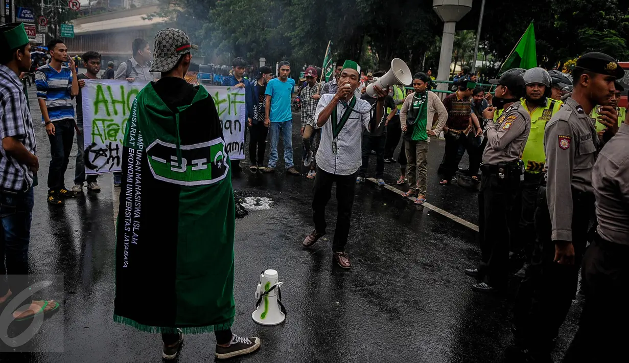 Aktivis HMI berorasi ketika melakukan demo dan bakar ban di Jalan Cikini, Jakarta, Sabtu (8/10). Mereka menuntut Basuki Tjahaja Purnama (Ahok) mempertanggungjawabkan pernyataannya yang dinilai mencederai kitab suci Alquran. (Liputan6.com/Faizal Fanani)
