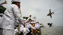 Setelah sampai di laut, pemimpin ritual akan melarung sesaji berupa hewan ternak serta bunga yang diletakkan di atas anyaman pandan sembari membacakan doa-doa. (JUNI KRISWANTO/AFP)