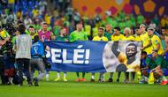 Para pemain Brasil membentangkan spanduk dukungan untuk Pele yang sedang sakit pada akhir pertandingan sepak bola babak 16 besar Piala Dunia 2022 antara Brasil dan Korea Selatan di Stadium 974, Doha, Qatar, 5 Desember 2022. (AP Photo/Andre Penner)