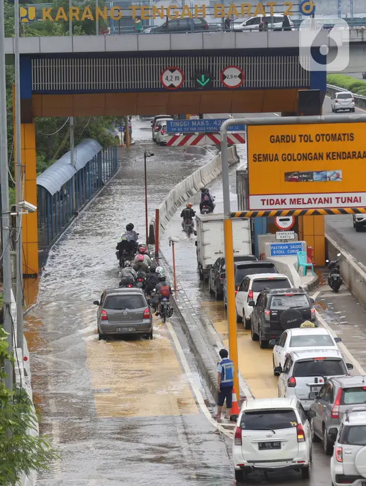 Sejumlah kendaraan melintasi Gerbang Tol Karang Tengah Barat 2 yang masih terendam banjir, Tangerang, Banten, Kamis (2/1/2020). Banjir setinggi betis orang dewasa masih menggenangi Gerbang Tol Karang Tengah Barat 2. (Liputan6.com/Angga Yuniar)