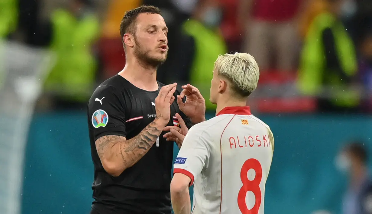 Usai pertandingan, Marko Arnautovic tampak berbincang dengan Gjanni Alioski. Alioski tampak meminta penjelasan dari Arnautovic atas cacian yang dilontarkannya. (Foto: AFP/Pool/Justin Setterfield)