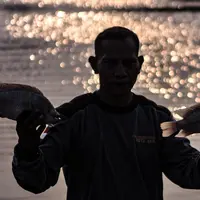 Warga menunjukkan bangkai ikan Mujair di Situ Rawa Besar, Lio, Depok, Jawa Barat, Kamis (20/8/2020). Sejak dua hari terakhir ribuan ekor ikan Mujair mati dan memenuhi Situ Rawa Besar yang menurut warga setempat disebabkan oleh faktor cuaca. (merdeka.com/Iqbal S. Nugroho)