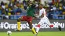 Bek Kamerun, Michael Ngadeu-Ngadjui, berhasil melewati gelandang Burkina Faso, Prejuce Nakoulma. Pada laga ini Kamerun menggunakan formasi 4-2-3-1, sementara Burkina Faso memakai skema 4-4-2. (AFP/Gabriel Bouys)