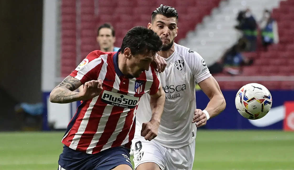 Bek Atletico Madrid, Stefan Savic (kiri) berebut bola dengan striker SD Huesca, Rafa Mir dalam laga lanjutan Liga Spanyol 2020/2021 pekan ke-32 di Wanda Metropolitano Stadium, Madrid, Kamis (22/4/2021). Atletico menang 2-0 atas SD Huesca. (AFP/Javier Soriano)