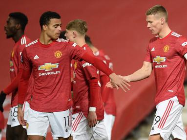 Gelandang Manchester United, Scott McTominay (kanan) melakukan selebrasi bersama rekan setim usai mencetak gol ke gawang Watford dalam laga babak ke-3 Piala FA 2020/21 di Old Trafford, Sabtu (9/1/2021). Manchester United menang 1-0 atas Watford. (AFP/Oli Scarff/Pool)