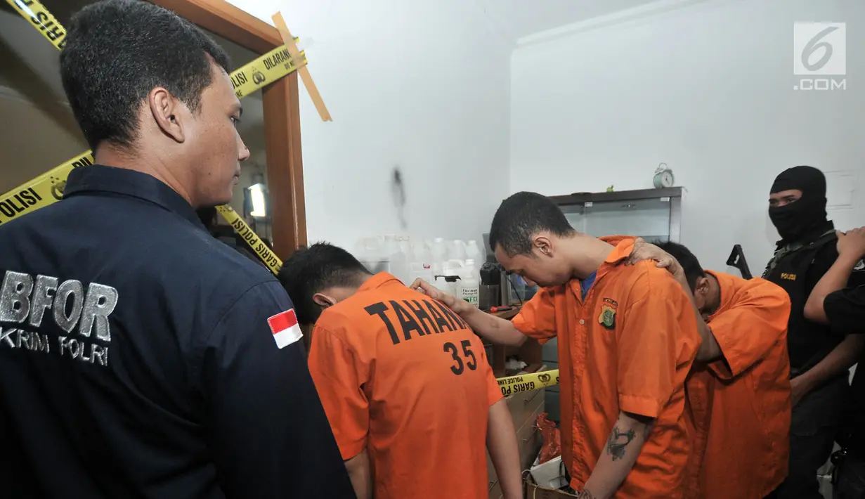 Polisi menggiring tersangka kasus pembuatan liquid vape narkoba di Kelapa Gading, Jakarta, Kamis (8/11). Sindikat pembuat liquid vape narkoba tersebut bernama 'Reborn Cartel'. (Merdeka.com/Iqbal Nugroho)
