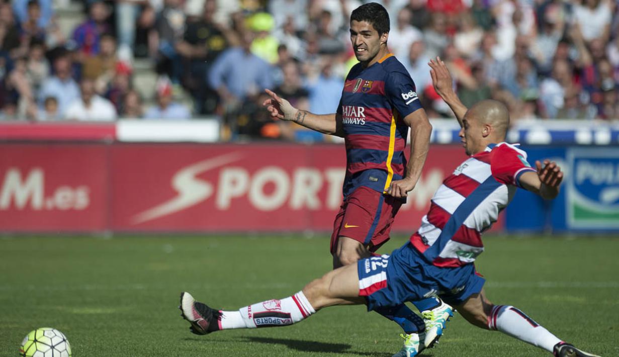 Striker Barcelona, Luis Suarez, melewati hadangan bek Granada, Matheus Doria, pada laga La Liga Spanyol. Ketiga gol mantan pemain Liverpool ini terjadi pada menit ke-22, 38 dan 88. (AFP/Jorge Guerrero)