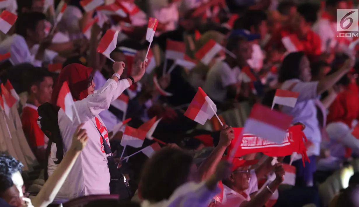Sejumlah relawan pendukung mengibarkan bendera Merah Putih jelang menyaksikan pidato Visi Indonesia yang akan disampaikan Presiden/Wakil Presiden terpilih 2019-2024, Joko Widodo dan KH Ma’ruf Amin di SICC, Kab Bogor, Jawa Barat, Minggu (14/7/2019). (Liputan6.com/Helmi Fithriansyah)