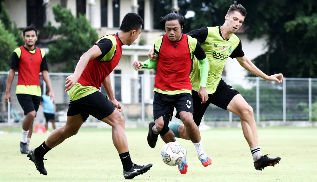 Pemain Persikabo 1973, Andre Oktaviansyah (tengah) berebut bola dengan Sergey Pushnyakov saat sesi latihan perdana di Lapangan Samudra, Badung, Bali, Minggu (03/01/2022). Latihan tersebut menjadi bagian dari persiapan menghadapi Arema FC  pada 5 januari mendatang. (Bola.com/Nandang Permana)