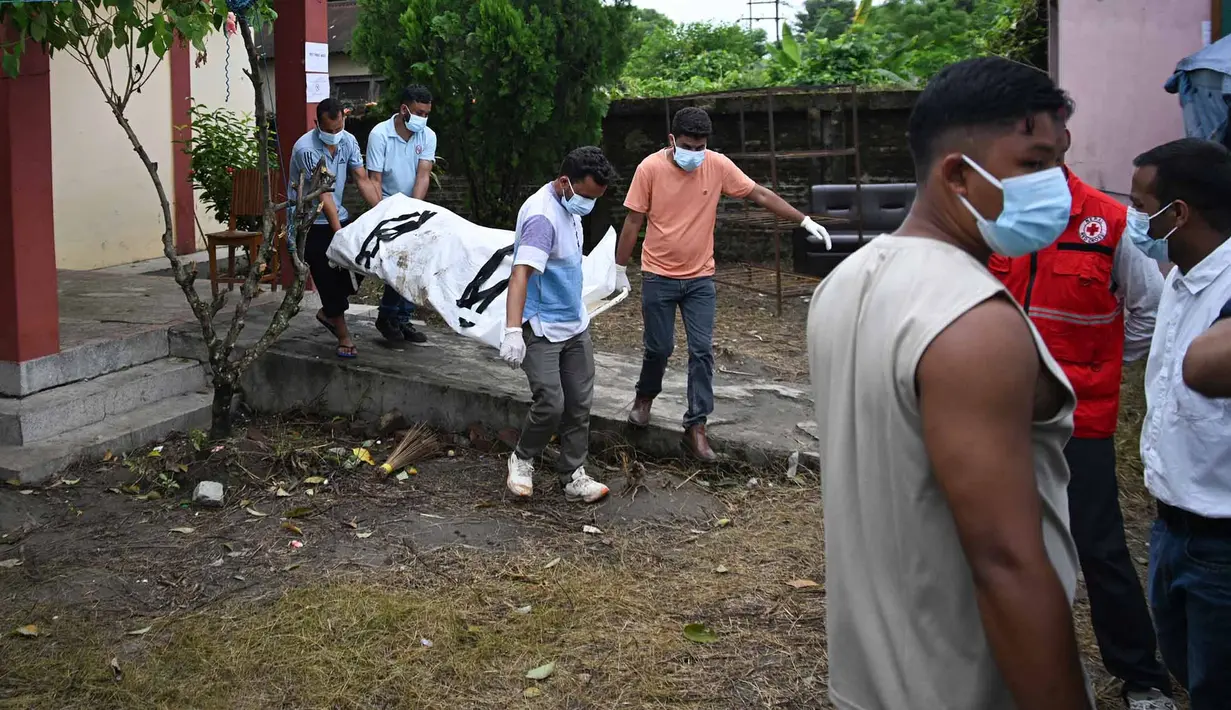 Petugas kesehatan membawa jenazah korban banjir bandang untuk dikremasi di luar kamar jenazah di distrik Chitwan, Nepal, Senin, 31 Agustus 2026. (AFP/ Prakash Mathema)