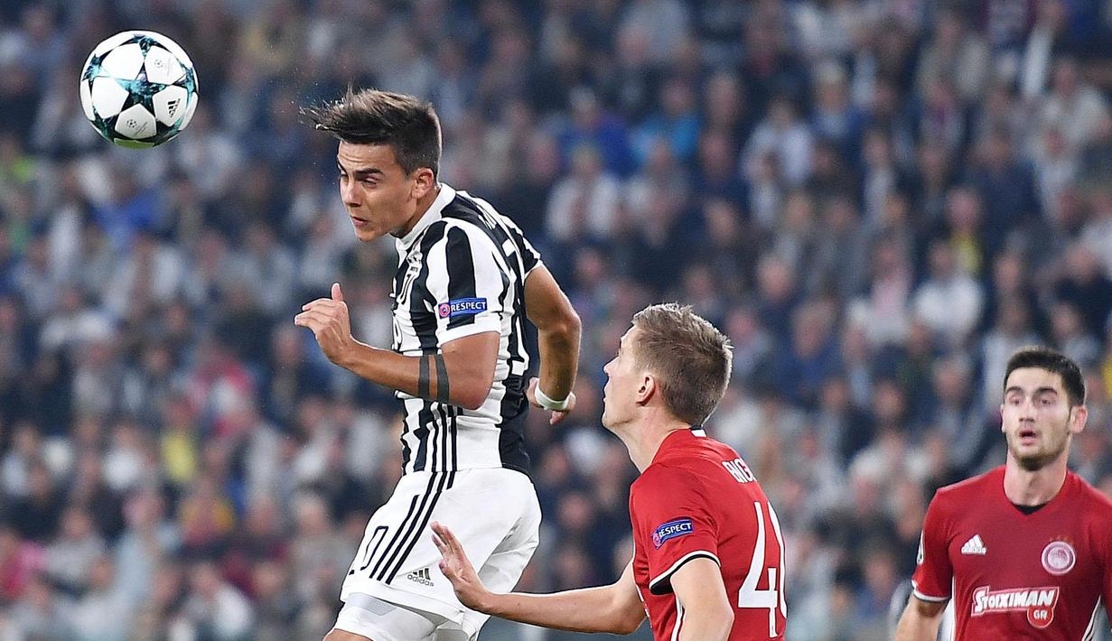 Aksi pemain Juventus, Paulo Dybala (kiri) menyundul bola melewati adangan pemain Olympiakos pada laga grup D Liga Champions di Allianz stadium, Turin, (27/9/2017). Juventus menang 2-0. (Alessandro Di Marco/ANSA via AP)