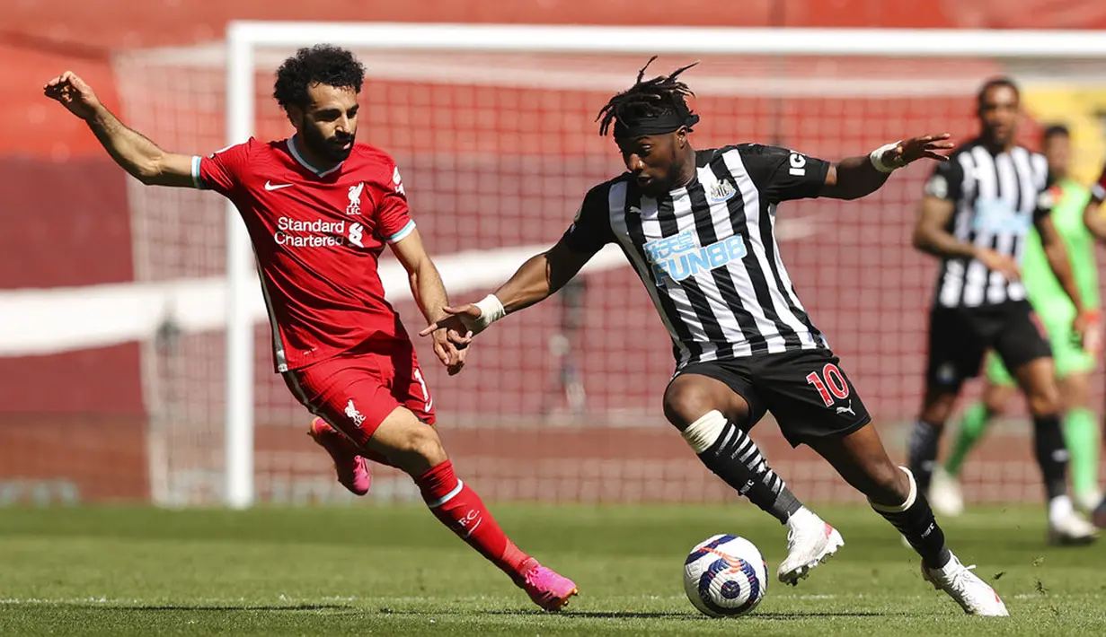 Pemain Newcastle United Allan Saint-Maximin (kanan) berebut bola dengan pemain Liverpool Mohamed Salah pada pertandingan Liga Inggris di Stadion Anfield, Liverpool, Inggris, Sabtu (24/4/2021). Pertandingan berakhir imbang 1-1. (Clive Brunskill, Pool via AP)
