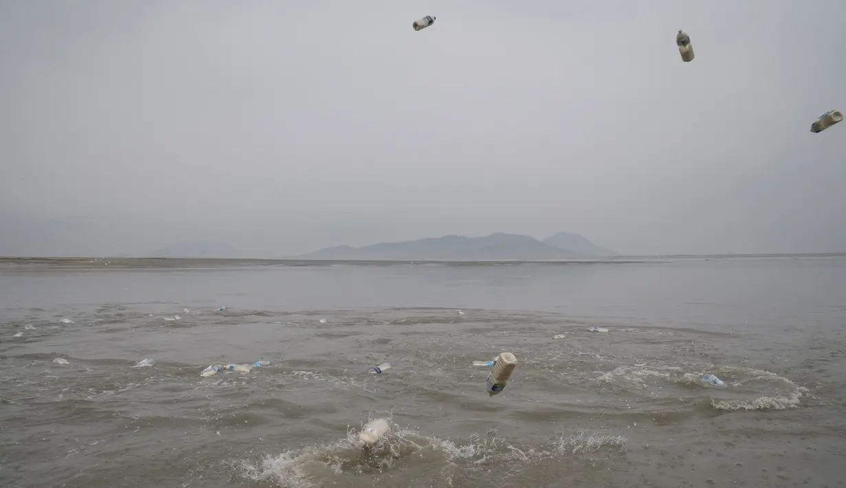 Aktivis pembelot Korea Utara melemparkan botol berisi beras, uang dan USB  ke laut dari pulau Ganghwa, barat Seoul, Selasa (1/5). Tidak ada yang tahu pasti apakah botol yang mereka apungkan dapat tiba dan diterima warga Korea Utara. (AFP/ED JONES)