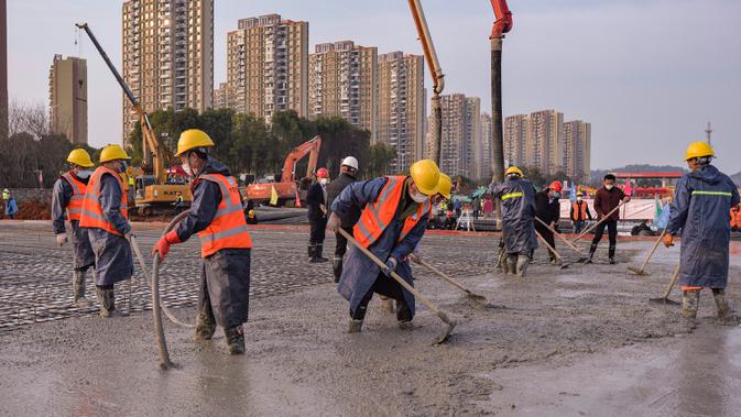 Gambar pada 28 Januari 2020, pekerja konstruksi di lokasi Rumah Sakit Huoshenshan yang sedang dibangun di Wuhan di Provinsi Hubei, China. Rumah sakit khusus pasien virus Corona yang berkapasitas 1.000 tempat tidur itu ditargetkan bisa digunakan pada 3 Februari mendatang. (Chinatopix via AP)