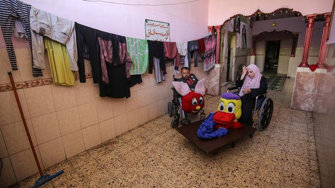 Nihad Jarboa (37) dan Zeinab (35) menjahit kostum kartun di rumah mereka di kamp pengungsi Rafah, Gaza, pada 19 Juli 2020. Mereka menjual kostum buatan tangan untuk mencari nafkah di bawah kondisi ekonomi yang keras di bawah blokade yang diberlakukan Israel sejak 2007. (AFP Photo/Said Khatib)