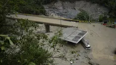 Sebuah truk tertutup lumpur di bawah jembatan yang ambruk saat longsoran maut yang juga melanda beberapa rumah di El Naranjal, Kolombia, Selasa, 18 Juli 2023. (AP Photo/Fernando Vergara)