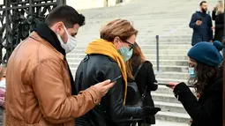 Pengunjung menunjukkan "Green Pass" di pintu masuk monumen Altare della Patria di Piazza Venezia, Roma, Minggu (5/12/2021). Kota Roma memberlakukan kewajiban penggunaan masker di ruang terbuka pusat kota dan area perbelanjaan sibuk lainnya hingga 31 Desember mendatang. (Vincenzo PINTO/AFP)