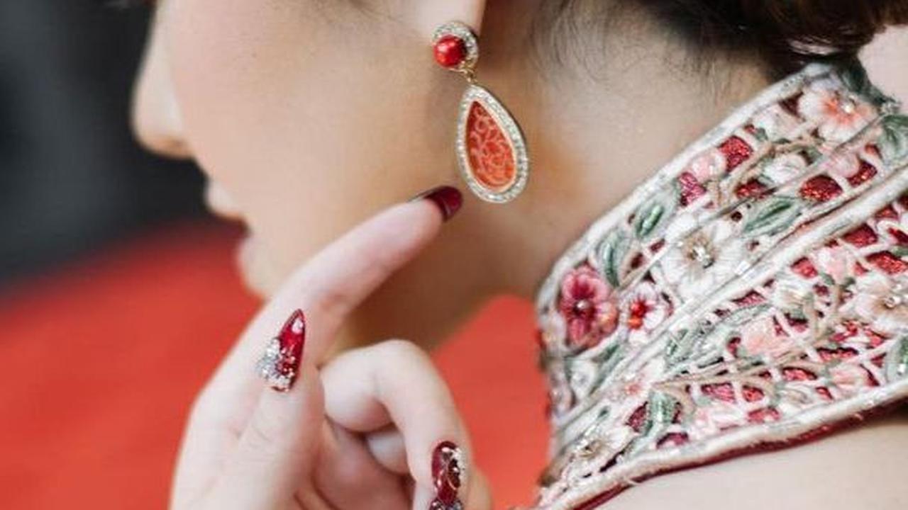 Pada bagian rambut, Tina Toon memakai aksesoris mutiara bak taman bunga dengan detail floral. Pesonanya sukses bikin pangling.
