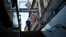 Seorang anggota masyarakat yang mengenakan masker untuk mengurangi penyebaran Covid-19, berjalan di bawah bendera Union saat memasuki Stasiun Westminster di London pusat (5/1/2022). Kasus Covid-19 harian negara itu menembus 200.000 untuk pertama kalinya. (AFP/Tolga Akmen)