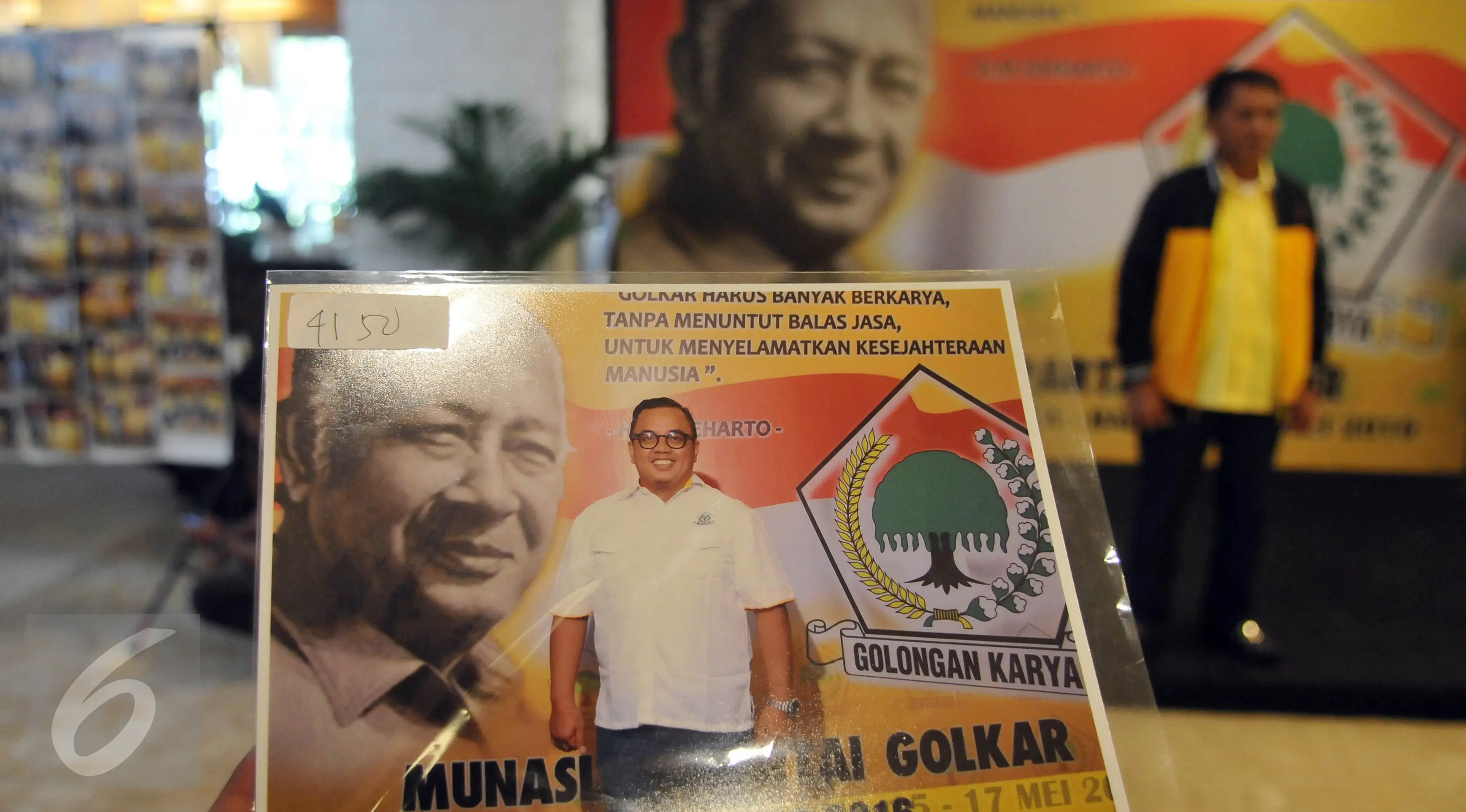 Kader partai menunjukkan hasil fotonya dengan latar belakang gambar Presiden kedua RI, Soeharto disela Musyawarah Nasional Luar Biasa (Munaslub) Partai Golkar di Bali Nusa Dua Convention Center (BNDCC), Bali, Minggu (15/5). (Liputan6.com/Johan Tallo)