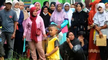 Seorang anak berdiri di antara warga yang antre saat penyaluran bantuan langsung tunai (BLT) Kemensos di Kecamatan Ciseeng, Bogor, Jawa Barat, Senin (28/11/2022). Setiap Keluarga Penerima Manfaat (KPM) mendapat BLT BBM sebesar Rp300ribu, Sembako Rp600 ribu dan bantuan PKH (Program Keluarga Harapan) sebesar Rp600 ribu. (merdeka.com/Arie Basuki)