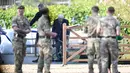 Personel militer menyambut veteran Perang Dunia II Kapten Tom Moore (99) di kebunnya di Marston Moretaine, London, 16 April 2020. Menjelang ulang tahunnya ke-100, Moore mengumpulkan donasi lebih dari 16 juta dolar untuk sumbangan bagi tenaga kesehatan yang menangani Covid-19. (Joe Giddens/PA via AP)