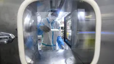 Seorang teknisi laboratorium yang mengenakan alat pelindung diri (APD) bekerja pada sampel yang akan diuji untuk virus corona Covid-19 di laboratorium Mata Api, fasilitas pengujian Covid-19, di Wuhan di provinsi Hubei tengah China (5/8/2021). (AFP/STR)