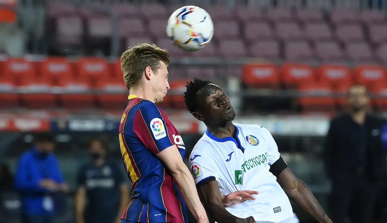 Gelandang Barcelona, Frenkie De Jong (kiri) berduel udara dengan bek Getafe, Djene Dakonam dalam laga lanjutan Liga Spanyol 2020/2021 pekan ke-32 di Camp Nou Stadium, Barcelona, Kamis (22/4/2021). Barcelona menang 5-2 atas Getafe. (AFP/Lluis Gene)
