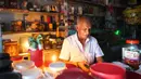 Seorang pria bekerja dengan bantuan lilin di toko miliknya di tengah pemadaman listrik di Kolombo, Sri Lanka (17/8/2020). Sri Lanka mengalami pemadaman listrik berskala nasional pada Senin (17/8) karena kerusakan teknis di sebuah pembangkit listrik di Kerawalapitiya. (Xinhua/A. Hapuarachchi)