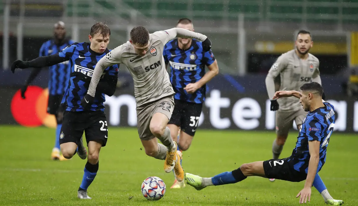 Pemain Shakhtar Donetsk, Mykola Matviyenko berusaha melewati dua pemain Inter Milan, Nicolo Barella dan Achraf Hakimi dalam laga lanjutan Grup B Liga Champions di stadion San Siro di Milan, Italia, Kamis (10/12/2020). (AP Photo/Antonio Calanni)