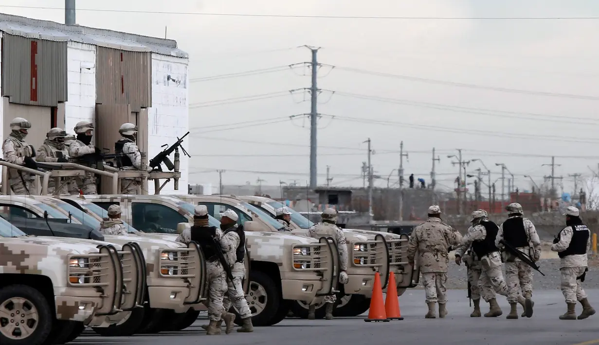 Tentara khusus Meksiko berjaga di bandara jelang ekstradisi gembong narkoba asal Meksiko, Joaquin "El Chapo" Guzman di Ciudad Juarez, Meksiko, (19/1). Guzman pertama kali tertangkap pada 1993 di Guatemala. (AP Photo/Christian Torres)