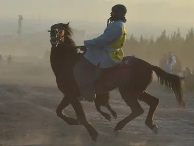 Penunggang kuda Afghanistan bersaing memperebutkan bangkai hewan dalam pertandingan Buzkashi di Herat, Afghanistan (4/2/2022). Buzkashi merupakan tradisi yang dilakukan oleh warga Afghanistan yang setiap pesertanya harus menunggang kuda. (AFP/Wakil Kohsar)