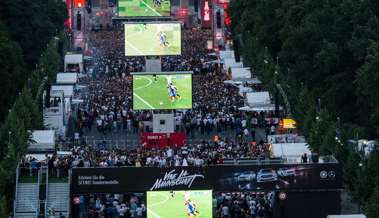 Suporter menonton laga semifinal piala eropa 2016 antara Prancis melawan Jerman lewat layar raksasa di Brandenburg Gate, Berlin, Jerman, (07/7/2016). (EPA/Paul Zinken)