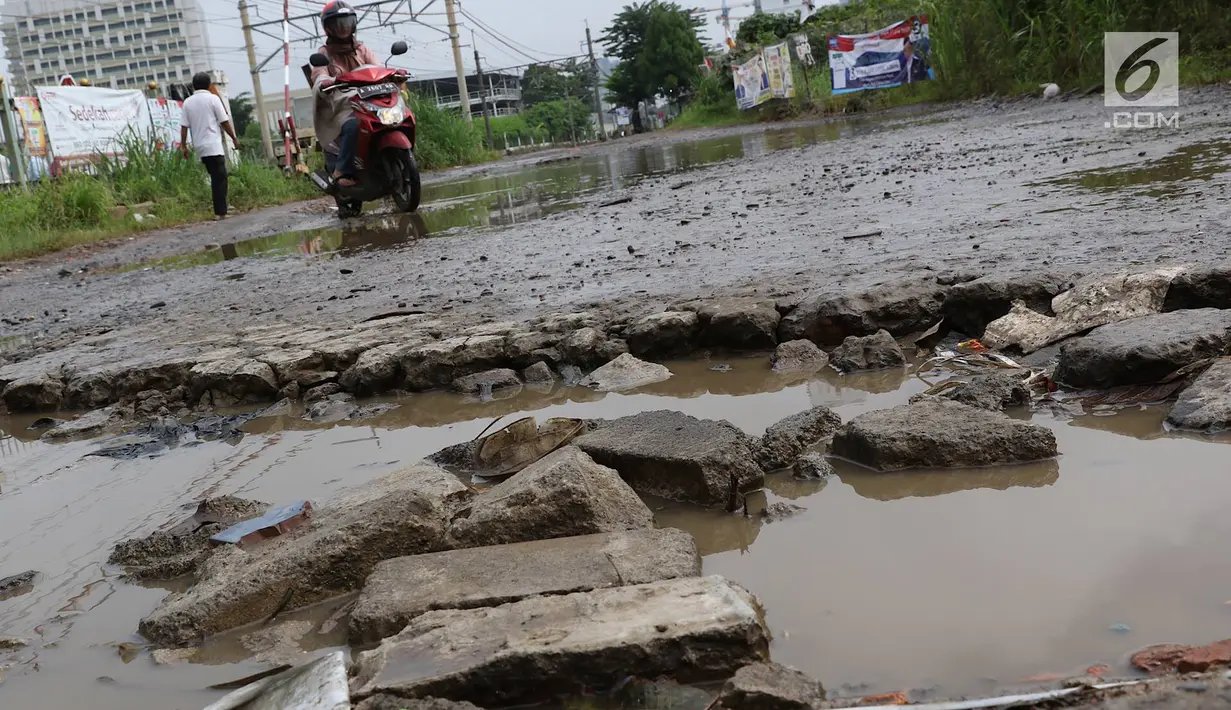 Kendaraan menghindari kubangan pada jalan yang rusak di Jalan Pertamina, Kemiri Muka, Depok, Jawa Barat, Selasa (5/3). Jalan rusak yang telah berlangsung bertahun-tahun tersebut tak kunjung diperbaiki. (Liputan6.com/Immanuel Antonius)