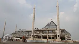 Motor melintas didepan proyek pembangunan Masjid Raya Jakarta di Jalan Daan Mogot KM 14, Jakarta, Senin (23/5). Proyek pembangunan Masjid Raya Jakarta direncanakan akan dilaksanakan kembali pada akhir Mei mendatang. (Liputan6.com/Gempur M Surya)