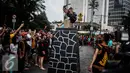 Seorang pria melakukan fahombo atau lompat batu dalam sebuah acara pagelaran seni dan kebudayaan Nias di Jalan Imam Bonjol, Jakarta, Minggu (12/2). Acara ini bertujuan untuk memperkenalkan kebudayaan Nias. (Liputan6.com/Faizal Fanani)