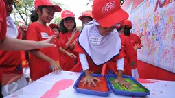 Siswa SD mmberikan cap tangan mereka sebagai bentuk dukungan gerakan cuci tangan dalam rangka memperingati Hari Cuci Tangan Sedunia di Pelataran Kantor Walikota Jakarta Barat, Jakarta (15/10/2015). (Liputan6.com/Gempur M Surya)