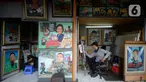 Seorang pelukis sedang menyelesaikan lukisan tokoh-tokoh nasional di Depan Pasar Baru, Jakarta, Kamis (24/12/2020). Di masa-masa awal pandemi para pelukis ini mengaku sepi pesanan, tapi kini mulai banyak pemesanan lukisan mulai tokoh nasional hingga para artis. (merdeka.com/Dwi Narwoko)