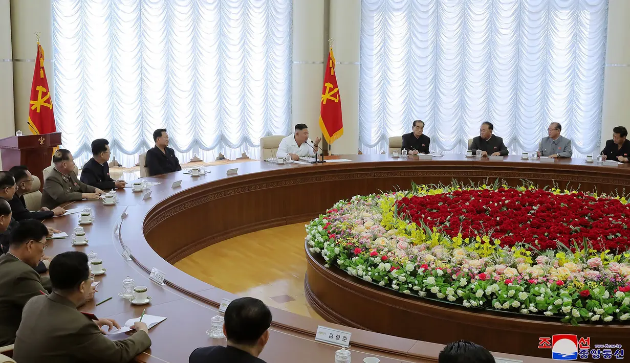 Pemimpin Korea Utara, Kim Jong-un (tengah) menghadiri pertemuan politbiro ke-13 dari Partai Buruh di lokasi yang dirahasiakan dalam gambar yang diambil Minggu (7/6/2020). Dalam pertemuan itu, Kim Jong-un juga membahas proyek-proyek ekonomi termasuk industri kimia. (Photo by STR / KCNA VIA KNS / AFP)