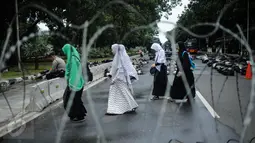 Masyarakat melintasi kawat berduri saat aksi bela islam 313 di Jalan Merdeka Barat, Jakarta, Jumat (31/3). Mereka menuntut kepada Presiden Jokowi agar melaksanakan undang-undang dengan mencopot gubernur terdakwa, Ahok . (Liputan6.com/Faizal Fanani)