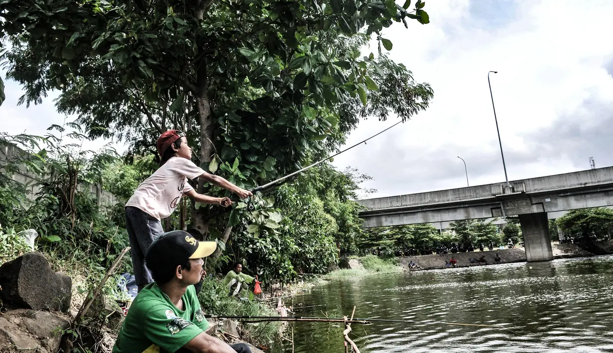 Seorang anak memancing di waduk kawasan Sungai Bambu, Tanjung Priok, Jakarta, Minggu (17/1/2021). Waduk buatan yang tepat berada di bawah Jalan Tol Pelabuhan tersebut menjadi wisata alternatif menghabiskan akhir pekan tanpa mengeluarkan biaya atau gratis. (merdeka.com/Iqbal S. Nugroho)