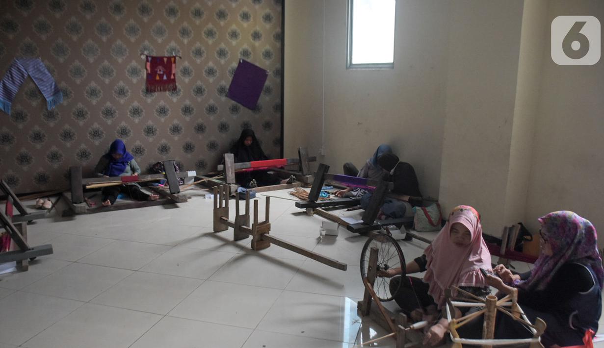 Warga mengikuti pelatihan pembuatan kain tenun motif Betawi di Rusunawa Jatinegara, Jakarta, Rabu (13/11/2019). Pemerintah akan memprioritaskan penyaluran KUR kelompok, seiring dengan diturunkannya suku bunga KUR per 1 Januari 2020 menjadi 6 persen, dari  7 persen. (Liputan6.com/Angga Yuniar)