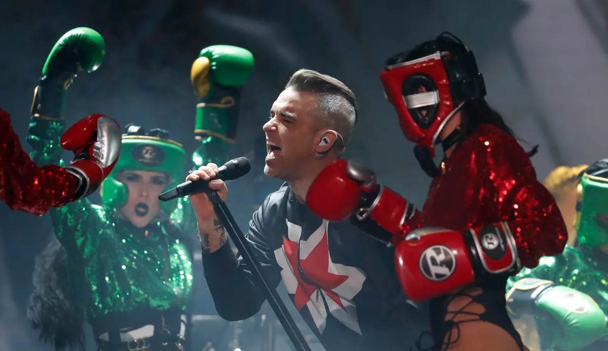 Penyanyi asal Inggris Robbie Williams bersama para penari cantik mengenakan sarung tinju dan pelindung kepala selama Festival Musik Corona Capital di Meksiko (17/11). (AP Photo/Eduardo Verdugo)