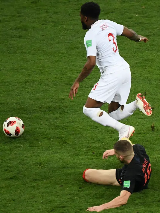 Penyerang Kroasia, Ante Rebic berebut bola dengan bek timnas Inggris, Danny Rose pada babak semifinal Piala Dunia 2018 di Stadion Luzhniki, Rabu (11/7). Rose menyita perhatian lantaran mengenakan kaus kaki yang berlubang. (AFP/ Jewel SAMAD)
