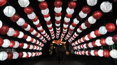 Pengunjung mengabadikan momen di depan salah satu lampion yang ditampilkan dalam Festival of Light di Monas, Jakarta, Rabu (14/8/2019). Festival lampion dan lampu laser bertemakan Kemerdekaan. (merdeka.com/Iqbal S. Nugroho)