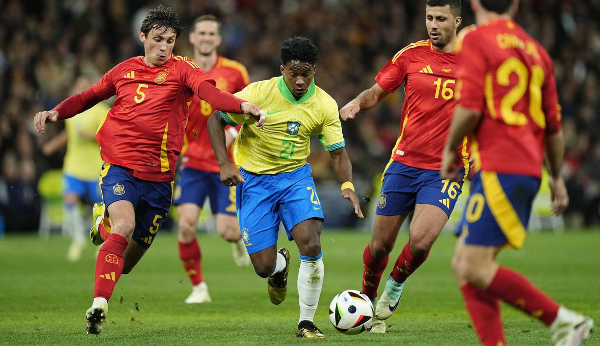 Pemain Brasil, Endrick (tengah) berusaha melewati sejumlah pemain Spanyol pada laga FIFA Matchday yang berlangsung di Santiago Bernabeu, Madrid, Spanyol, Rabu (27/03/2024) WIB. (AP Photo/Jose Breton)