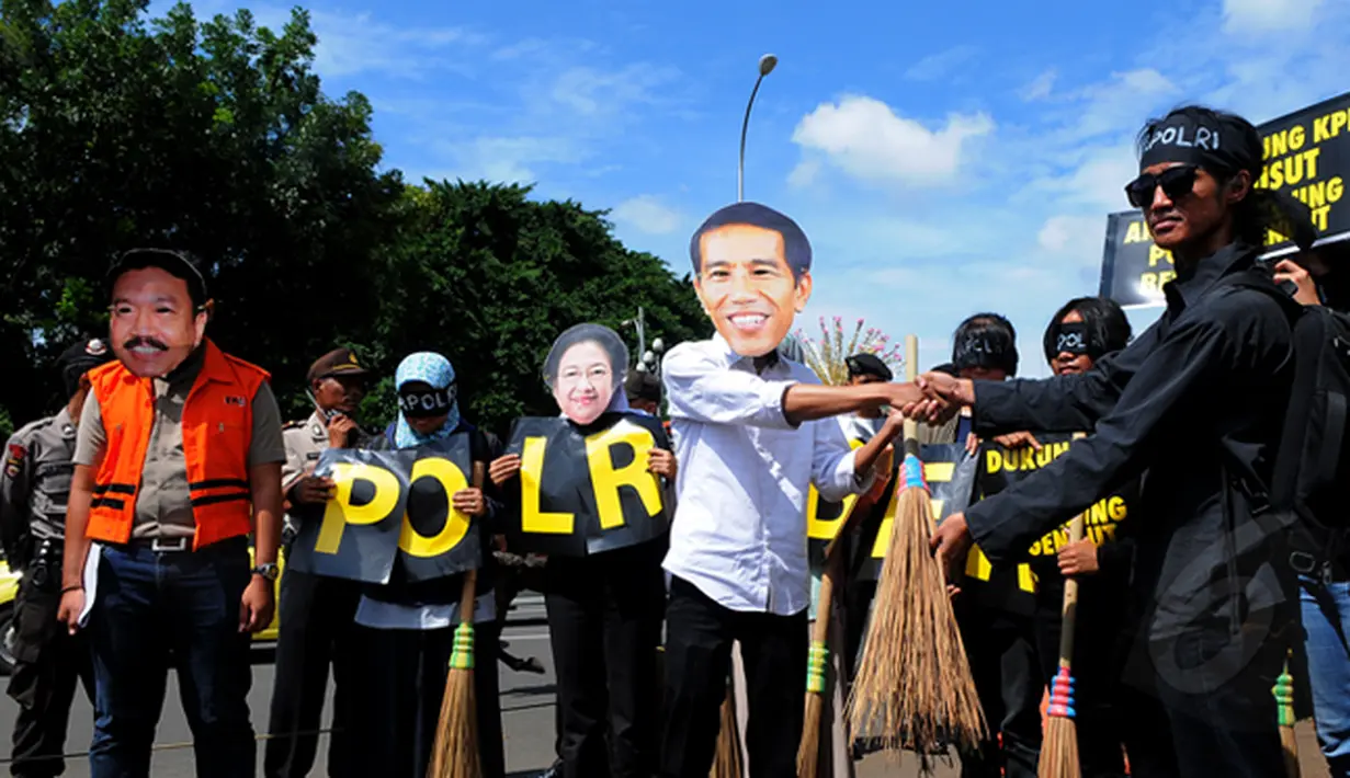 Puluhan massa melakukan aksi teatrikal menggambarkan sapu lidi sebagai simbol 'besih-besih',  Jakarta, Rabu (21/1/2015). Aksi unjuk rasa ini dilakukan untuk menolak pencalonan Komjen Budi Gunawan (BG) menjadi Kapolri. (Liputan6.com/Faisal R Syam)