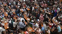 Pengunjung menikmati bir selama Festival Oktoberfest 2019 di sebuah tenda di Munich, Jerman selatan (3/10/2019). Festival bir terbesar di dunia Oktoberfest berlangsung hingga 6 Oktober 2019. (AFP Photo/Christof Stache)