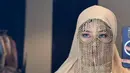 Dara Arafah tampil menawan mengenakan abaya warna biru muda yang dipadukan hijab warna krem dan chain face mask ala Arab sebagai aksesori. [@daraarafah]